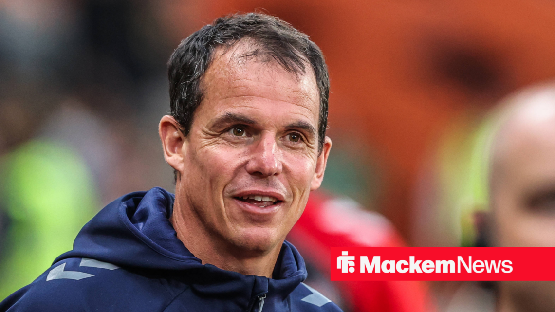 A close-up of Regis Le Bris forcing a smile in a Sunderland hooded jacket.