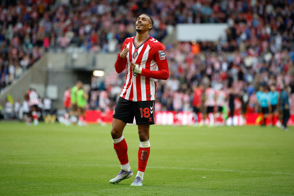 Wilson Isidor points to the Sunderland badge in front of supporters.