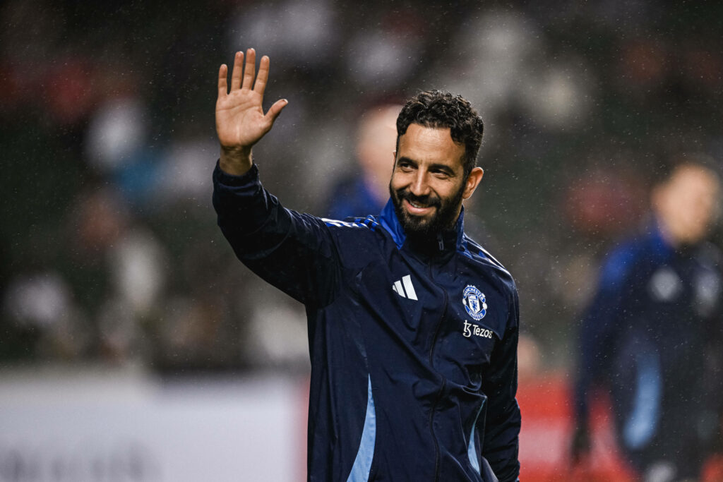 Ruben Amorim waves to supporters in a Man United tracksuit.
