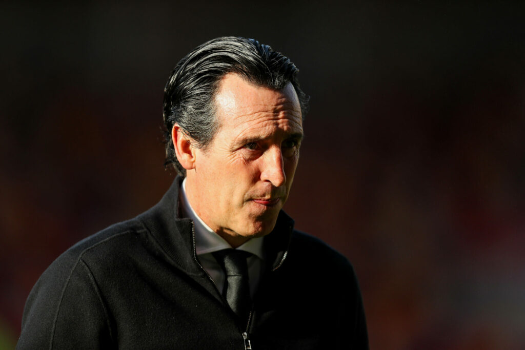 Unai Emery looks ahead with a dark background.