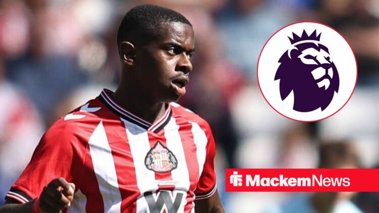 Noah Sadiki looking at the Premier League badge.