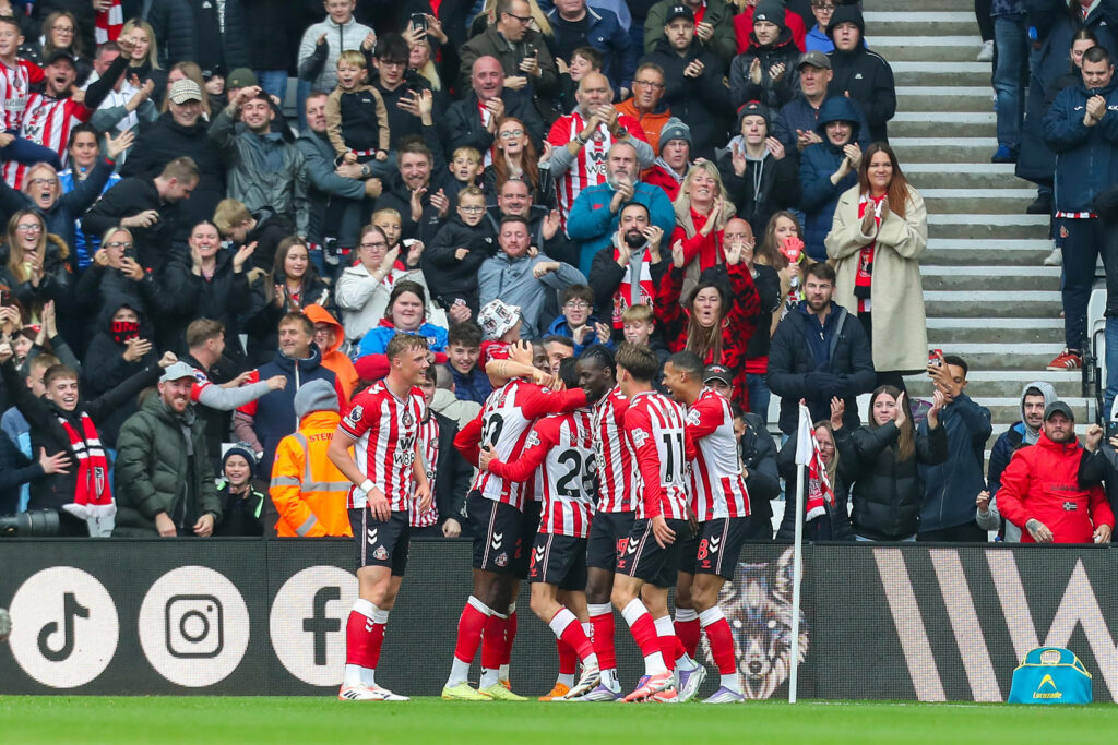 Sunderland players celebrate a goal in front of their fans.